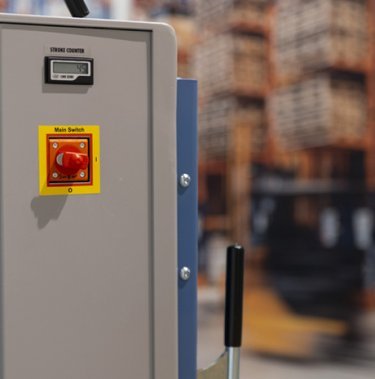 Do czego służy czerwony przycisk na prasie belującej?