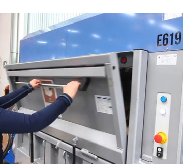 Pracownik otwiera dużą elektryczną Belownicę do plastiku